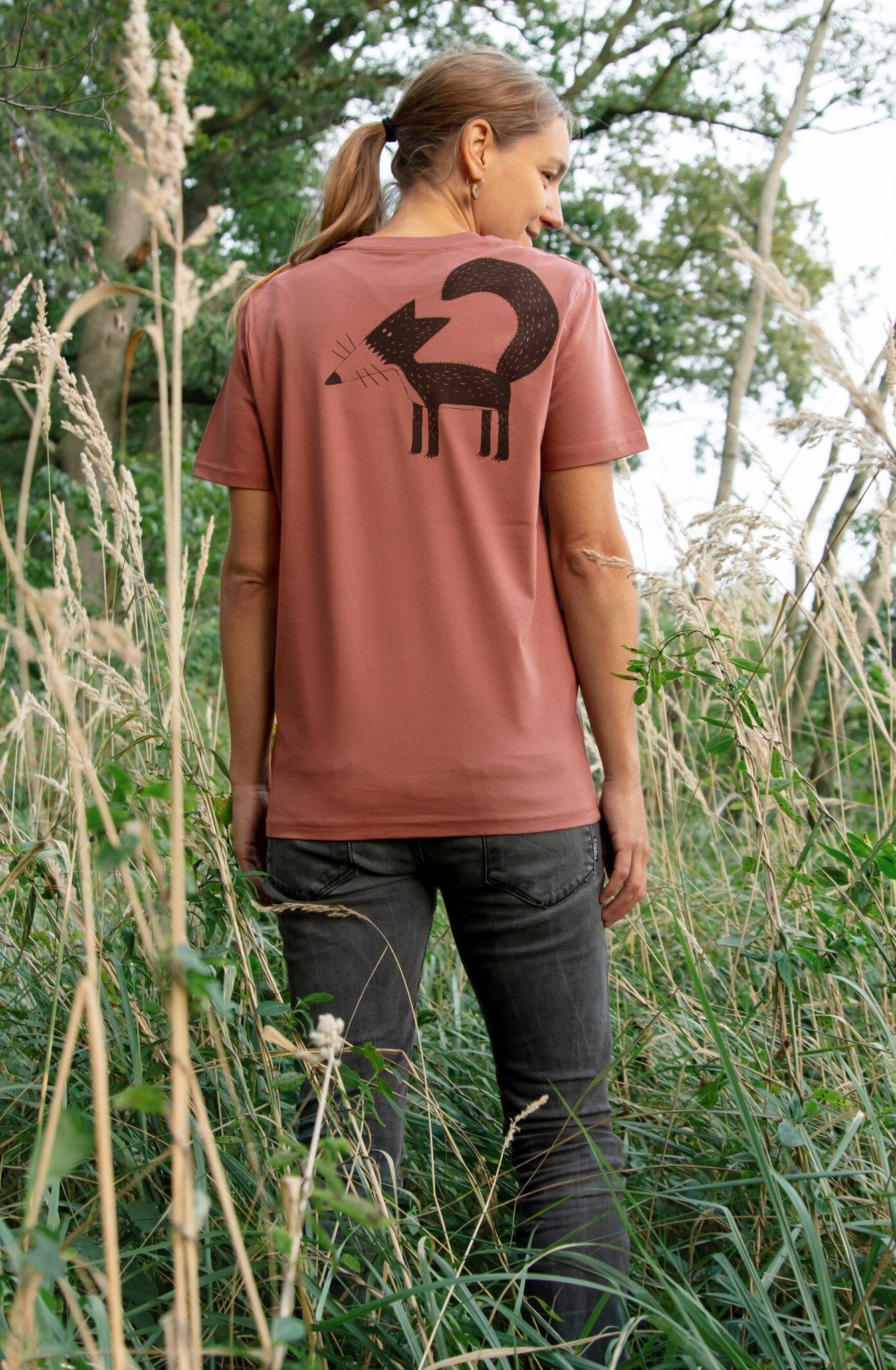 Fuchs T-Shirt für Damen in Heritage Braun. Eine Frau trägt das braune Baumwoll-Shirt und zeigt das detailreiche Grafik-Motiv des Fuchses in einer stilvollen Tragevariante.