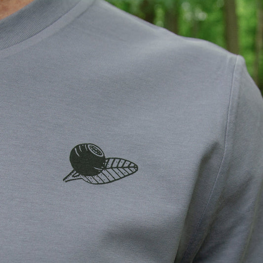 Blaubeere Tshirt mit kleinem, dezentem Motiv in der Nahaufnahme. Detailansicht des filigranen, handbedruckten Siebdrucks auf dem blaugrauen Bio-Baumwoll-Stoff aus dem Atelier in Hannover.