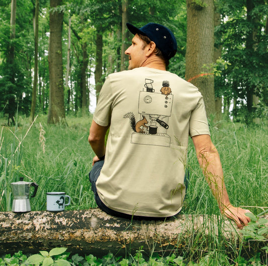 Kaffee T-Shirt für Männer im hellen Farbton Stone. Ein Mann sitzt im Wald in der Rückansicht und präsentiert den lustigen Eichhörnchen-Backprint auf dem nachhaltigen Bio-Shirt.