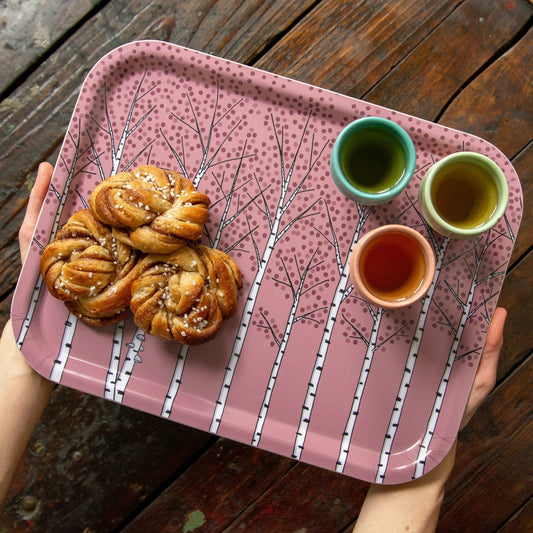 Schwedisches Design Holztablett für die gemütliche Fika-Pause. Mittleres altrosa Serviertablett mit Birken-Muster, reichlich gedeckt mit drei Kaffeetassen und schwedischen Zimtschnecken für Gäste.