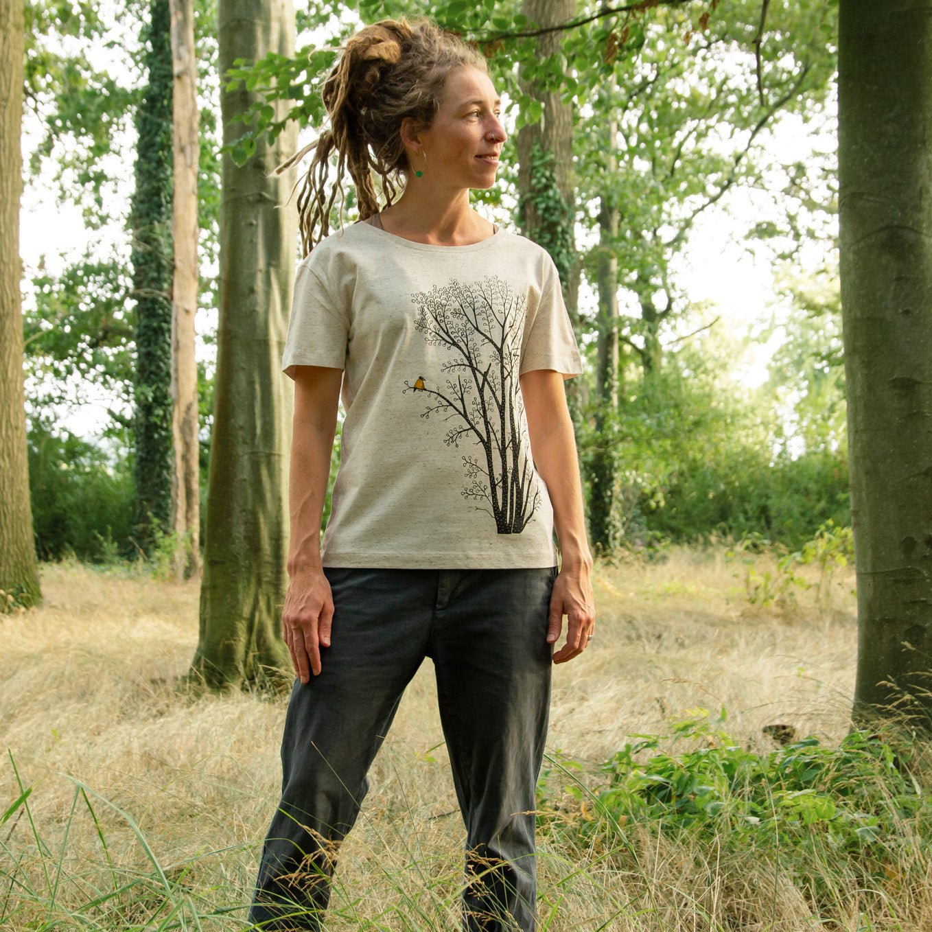 Damen Bio-T-Shirt mit großem Baum-Motiv, Erle und Elster, getragen von einer Frau im Wald