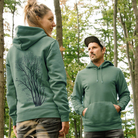 Hoodie mit Baum Motiv im Unisex-Schnitt. Eine Frau zeigt die Rückansicht mit dem großen, botanischen Pflanzen-Backprint, während daneben ein Mann die Vorderansicht trägt.
