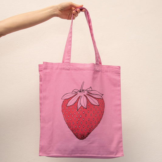 Erdbeer Jutebeutel in Bubble Pink als originelle Geschenkidee für Früchte-Fans. Nachhaltige pinke Tote Bag aus Bio-Baumwolle mit der großen Erdbeer-Illustration.
