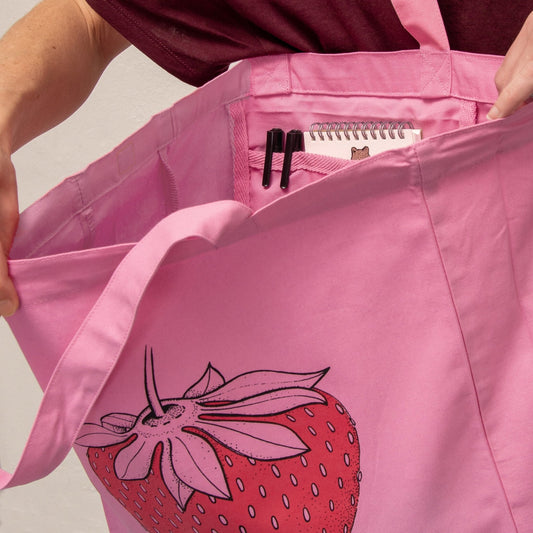 Stoff-Detailansicht der pinken Erdbeer Tote Bag. Hochwertiges Geschenk aus robustem Bio-Baumwoll-Stoff mit präzisen Nähten, handbedruckt im eigenen Atelier in Hannover.
