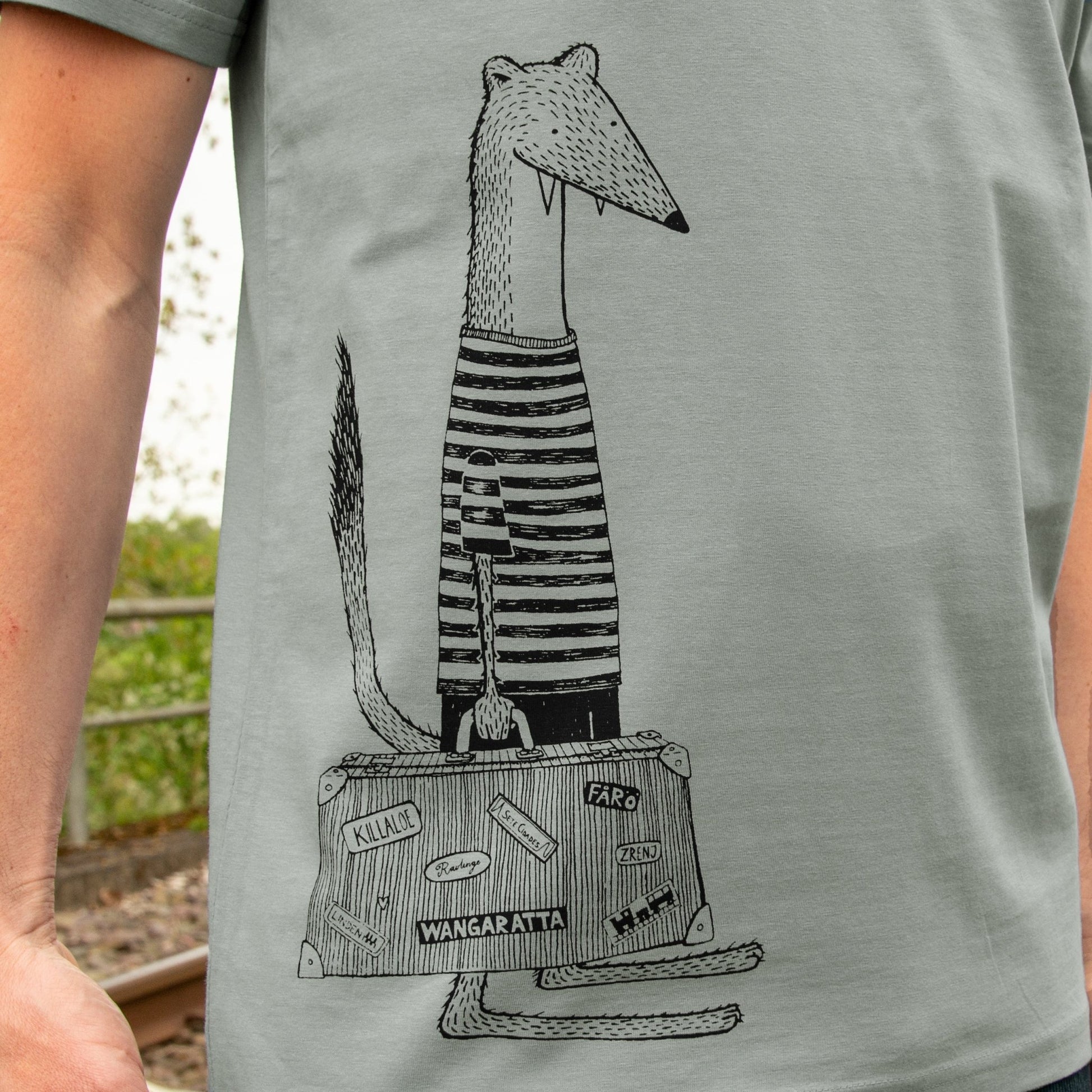 Wiesel Tshirt Grafik-Design mit Reisekoffer in der Nahaufnahme. Detailansicht des kunstvollen Urlaubs-Siebdrucks auf dem grauen Bio-Stoff, handbedruckt im eigenen Atelier in Hannover.
