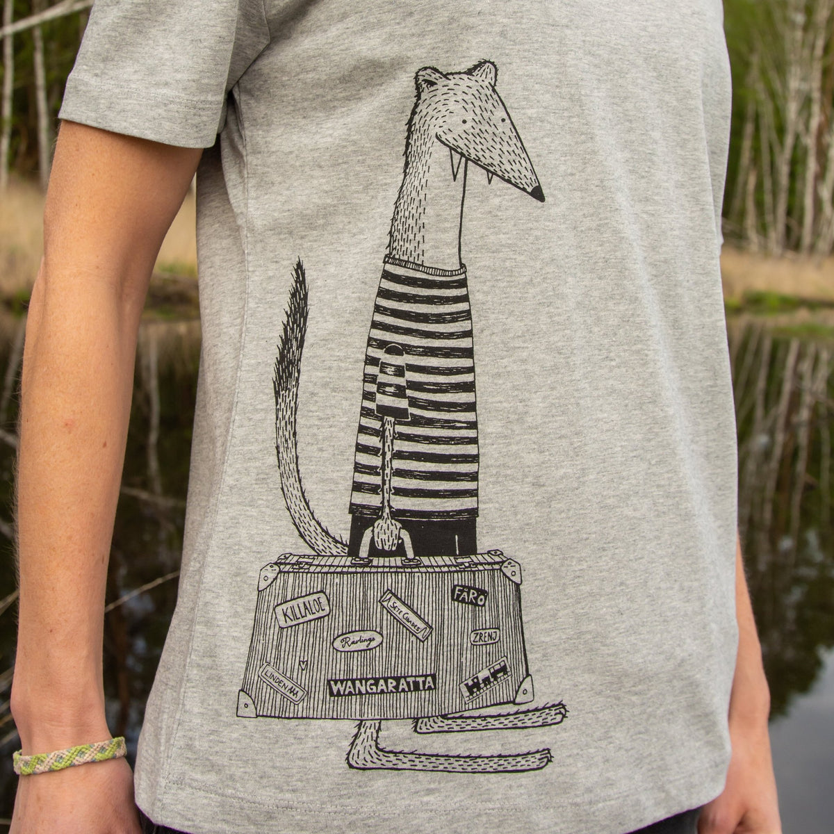 Wiesel Tshirt Grafik-Design mit Reisekoffer in der Nahaufnahme. Detailansicht des kunstvollen Siebdruck-Motivs auf dem grau melierten Bio-Stoff, handbedruckt im eigenen Atelier in Hannover.
