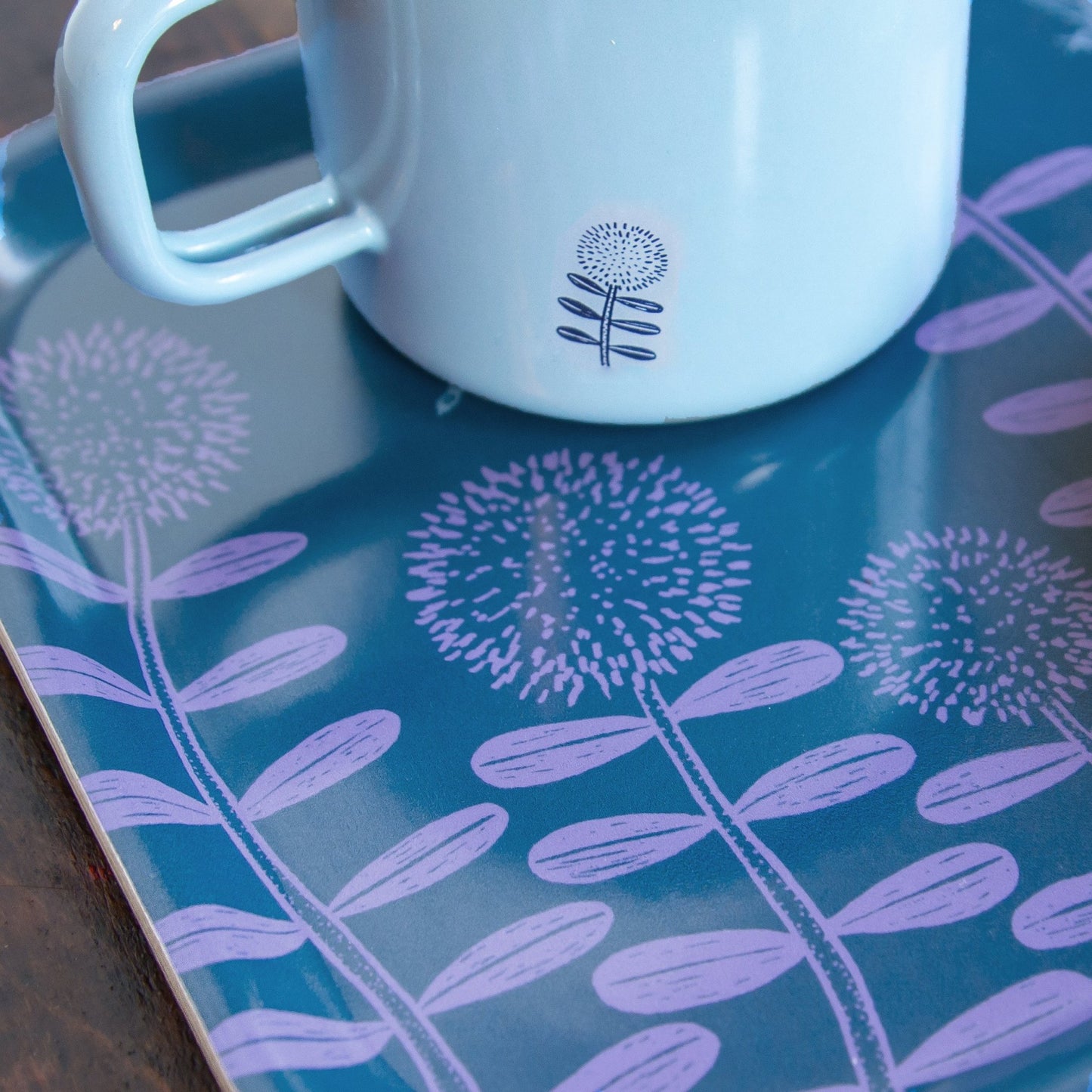 Deko-Tablett aus Holz im schwedischen Design mit neuer Cmig Emaille-Tasse. Kleines blau-lilas Frühstückstablett, perfekt dekoriert mit unserer handillustrierten hellblauen Emailletasse mit kleinen Frühlingsblumen für Naturliebhaber.