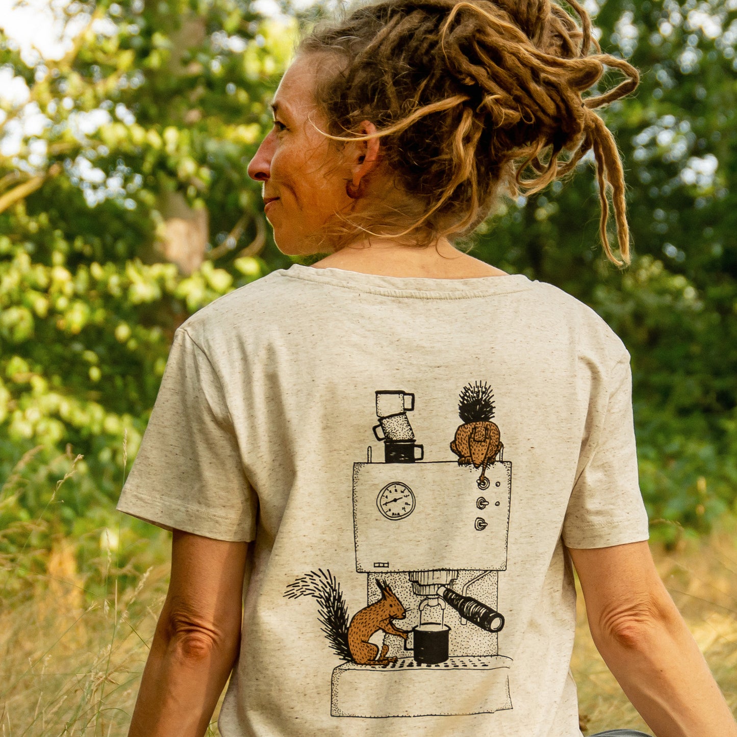 Nahaufnahme des Print-Motivs auf dem Kaffee T-Shirt. Detailansicht des Grafik-Drucks mit einem Eichhörnchen und einem Hörnchen, die eine Espressomaschine bedienen.