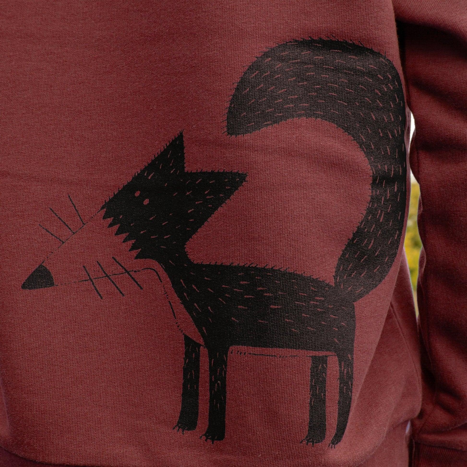 Siebdruck Nahaufnahme des Fuchs-Motivs Franzi auf dem weinroten Damen Pullover. Detailansicht des wasserbasierten Siebdrucks auf dem edlen Burgundy Sweatshirt-Stoff.
