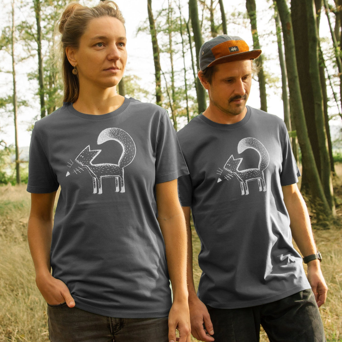 Fuchs T-Shirt im grauen Unisex-Schnitt für Damen und Herren. Eine Frau und ein Mann stehen im Wald und präsentieren das detailreiche Franzi-Fuchs-Motiv als hochwertigen Frontprint auf der Vorderseite.

