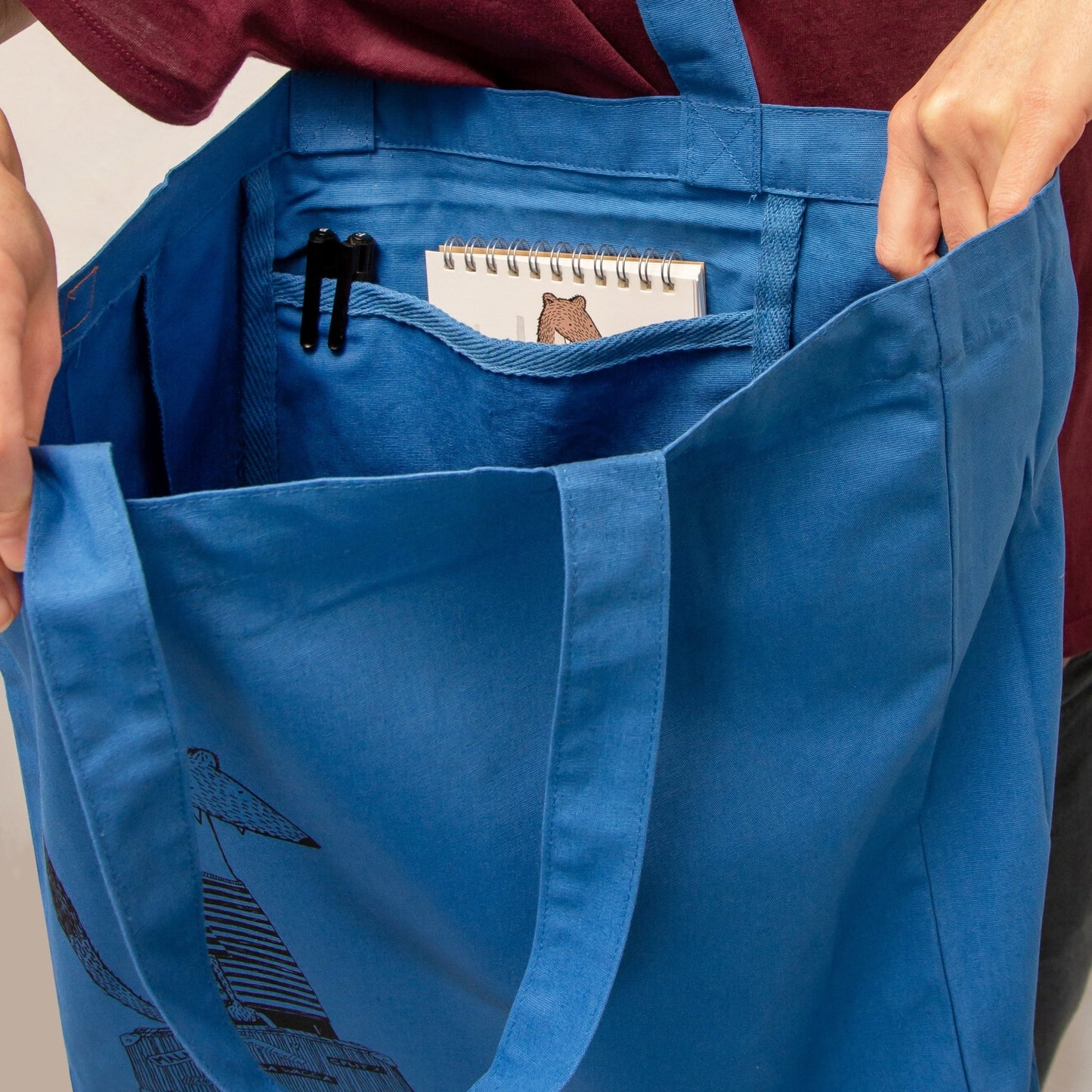 Stoff-Detailansicht der blau-grauen Wiesel Tote Bag. Hochwertiges Urlaubs-Geschenk aus robustem Bio-Baumwoll-Stoff mit präzisen Nähten, handbedruckt im eigenen Atelier in Hannover.
