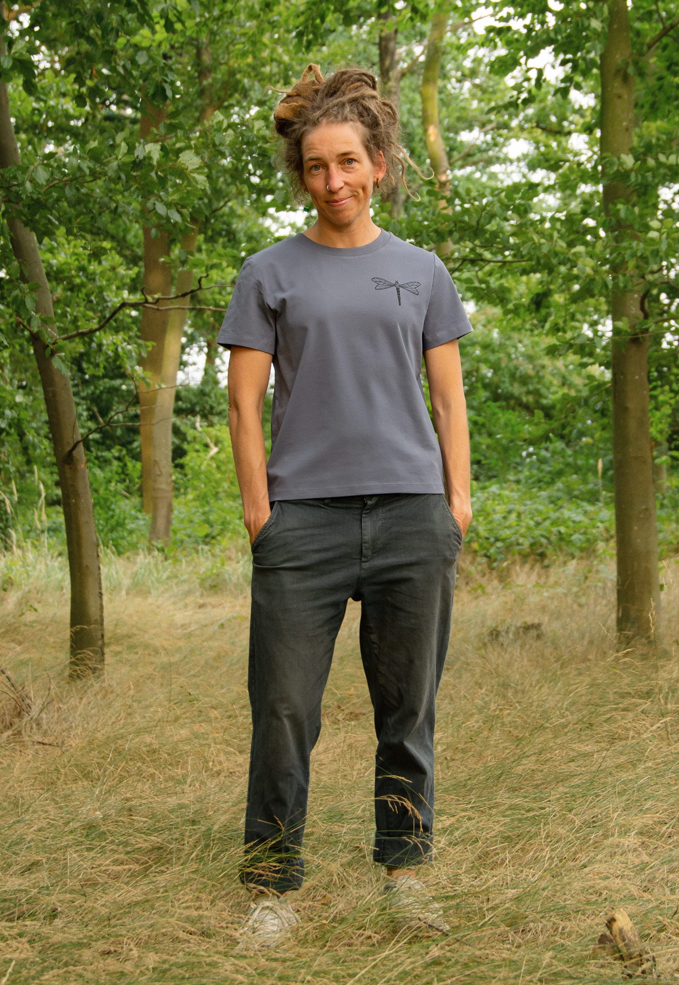 Damen Bio-T-Shirt in Blau-Grau mit Libellenmotiv, Model ganz im Wald zu sehen