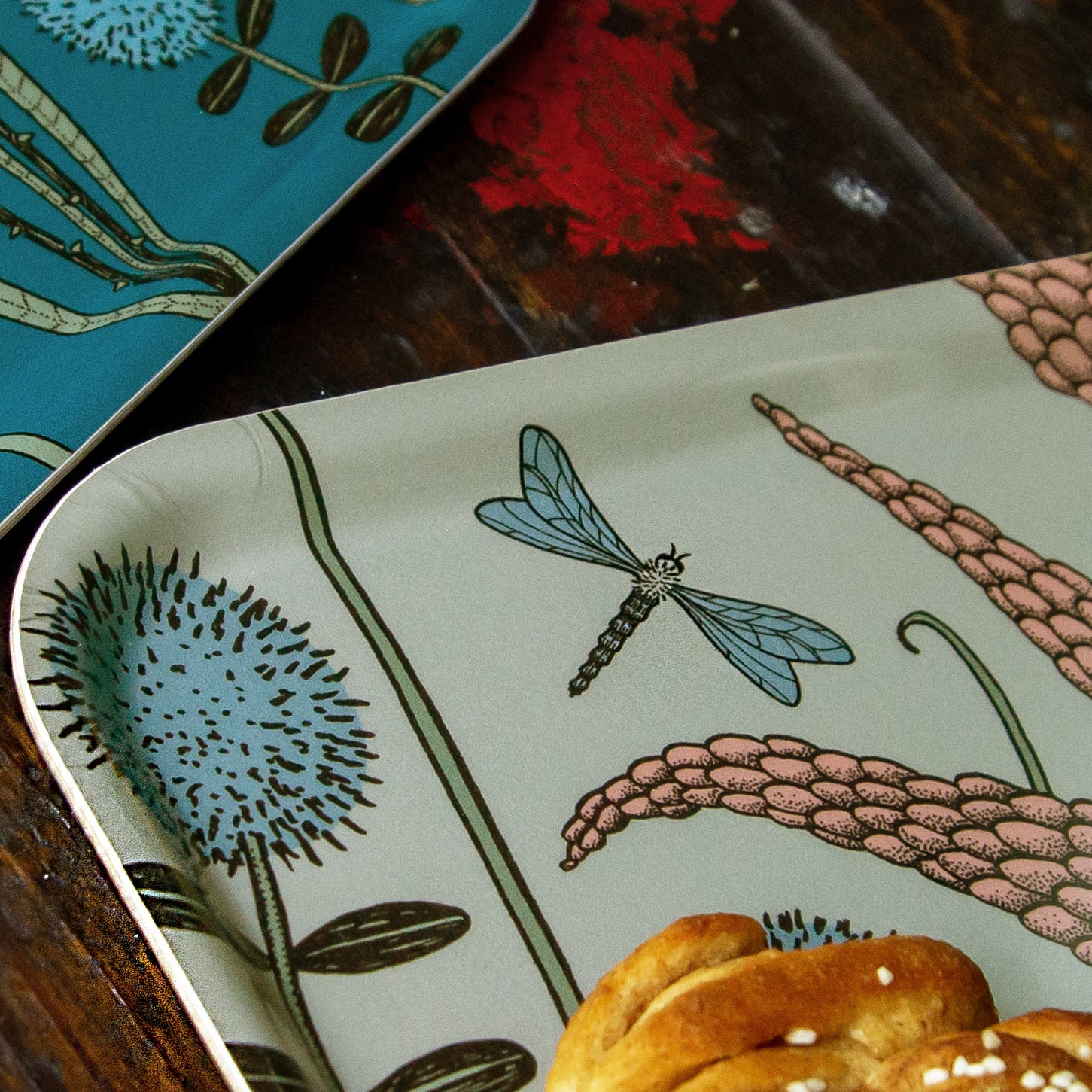 Nahaufnahme von einer botanischen Blumenwiese-Illustration mit Libellen-Motiv als kinderteller. Detailansicht des salbeigrünen Serviertabletts im Scandi-Style mit filigranem floralen Muster auf wasserunempfindlicher Beschichtung.