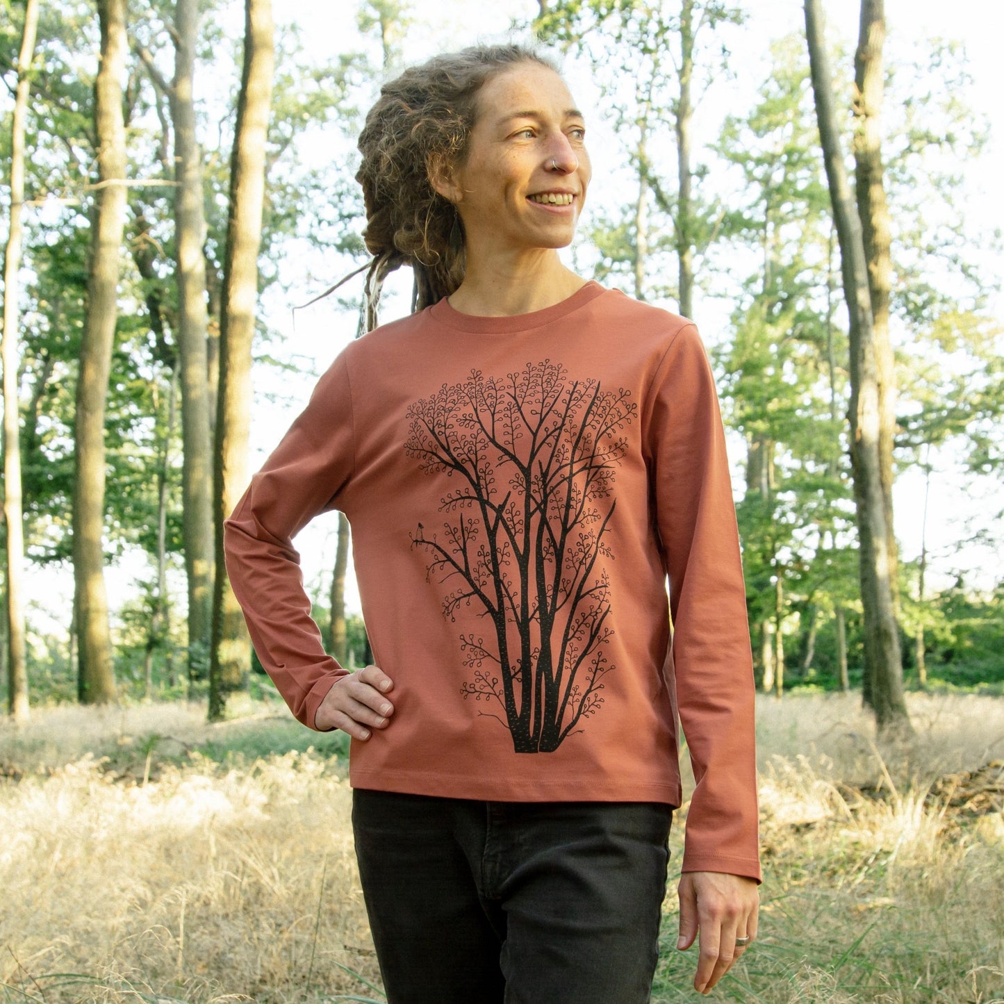 Pullover Baum Kollektion im lässigen Look für Damen. Eine Frau trägt das dünne Langarm-Sweatshirt mit dem gut sichtbaren, botanischen Pflanzen-Motiv von vorne.
