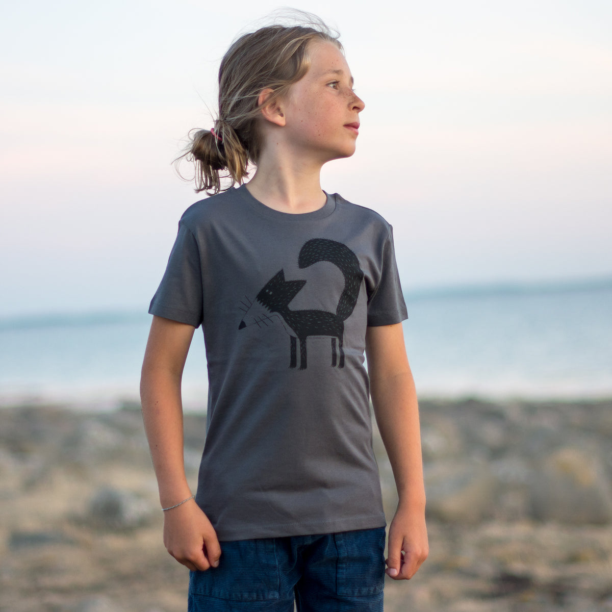 Fuchs T-Shirt für Kinder in anthrazit, getragen von einem Jungen am Strand.
