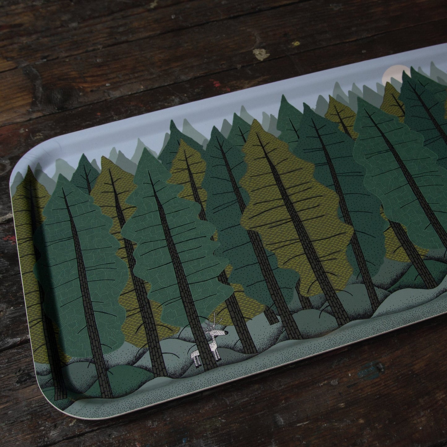 Großes rechteckiges Holztablett im skandinavischen Design aus schwedischer Produktion. Studio-Ansicht des Tannenwald-Tabletts (53x32 cm) mit Rentier-Motiv aus einem anderen Blickwinkel. Hochwertiges Naturmaterial von der Insel Öland.