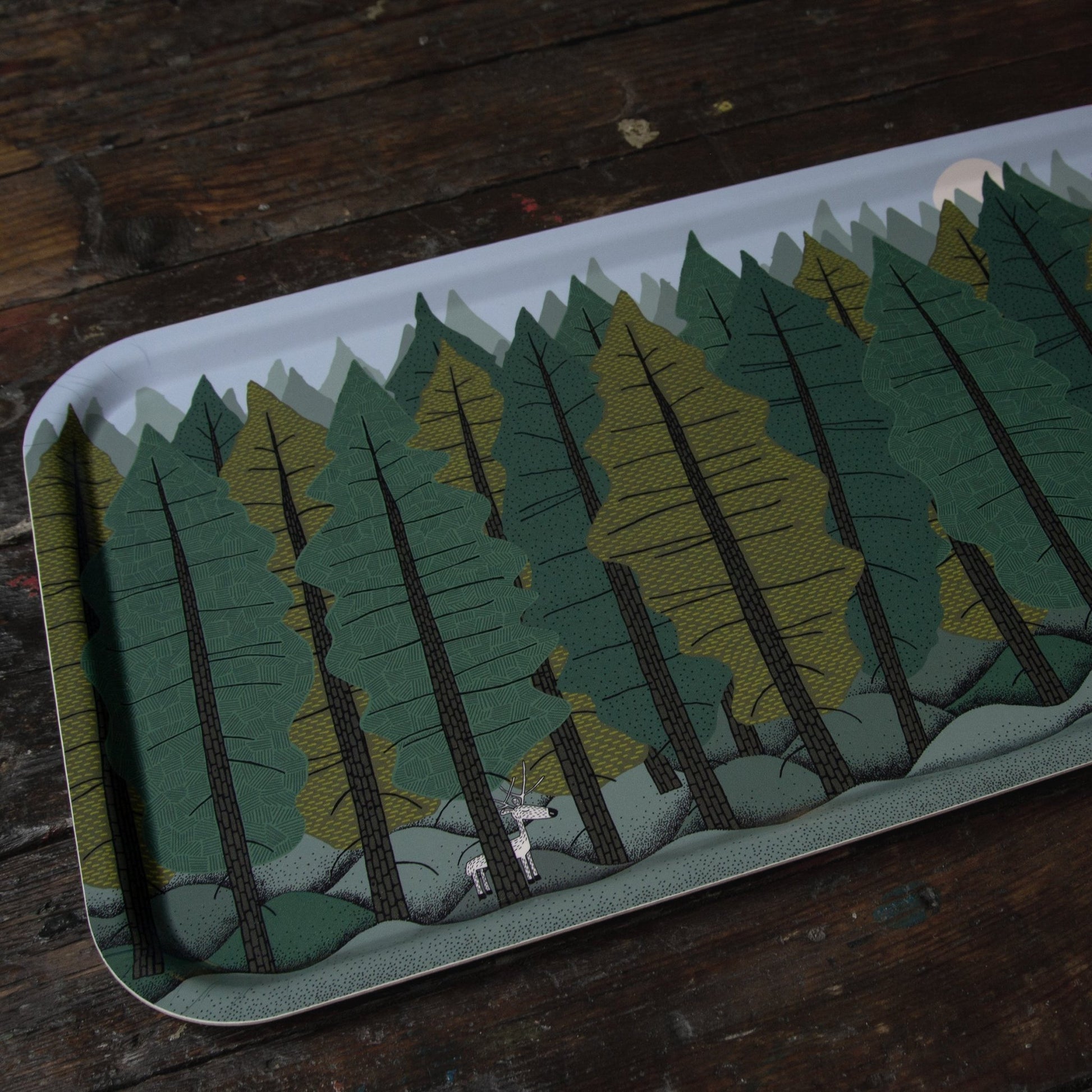 Großes rechteckiges Holztablett im skandinavischen Design aus schwedischer Produktion. Studio-Ansicht des Tannenwald-Tabletts (53x32 cm) mit Rentier-Motiv aus einem anderen Blickwinkel. Hochwertiges Naturmaterial von der Insel Öland.